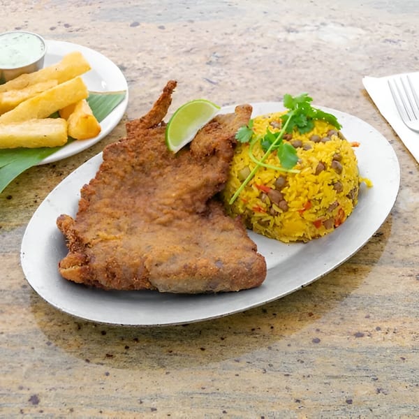 Amore Sabores' fried fish with yellow rice and a side of yucca fries and dipping sauce.